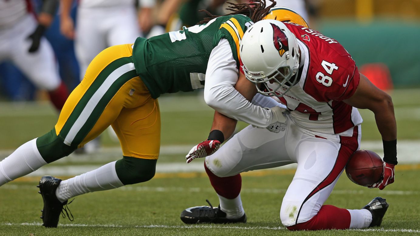 Rob Housler of the Cardinals can't hold on to the ball as he is hit by Jerron McMillian of the Packers on Sunday.