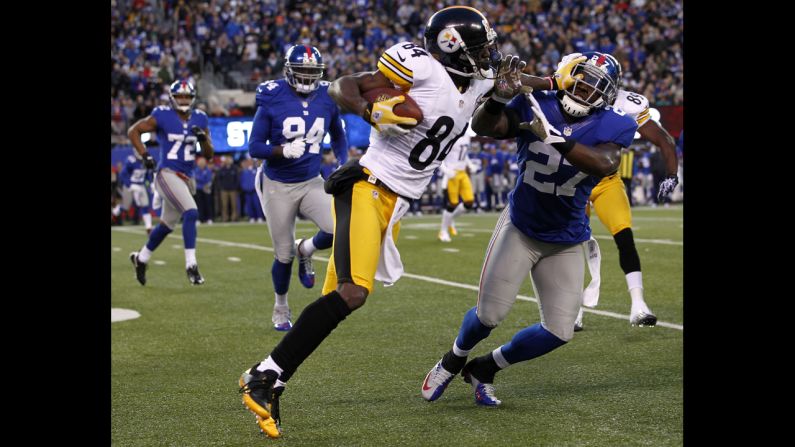 The Steelers' Antonio Brown fends off Stevie Brown of the Giants.