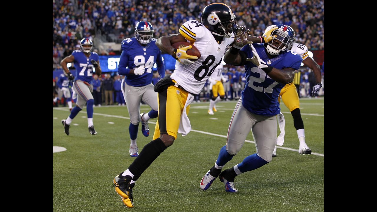 The Steelers' Antonio Brown fends off Stevie Brown of the Giants.