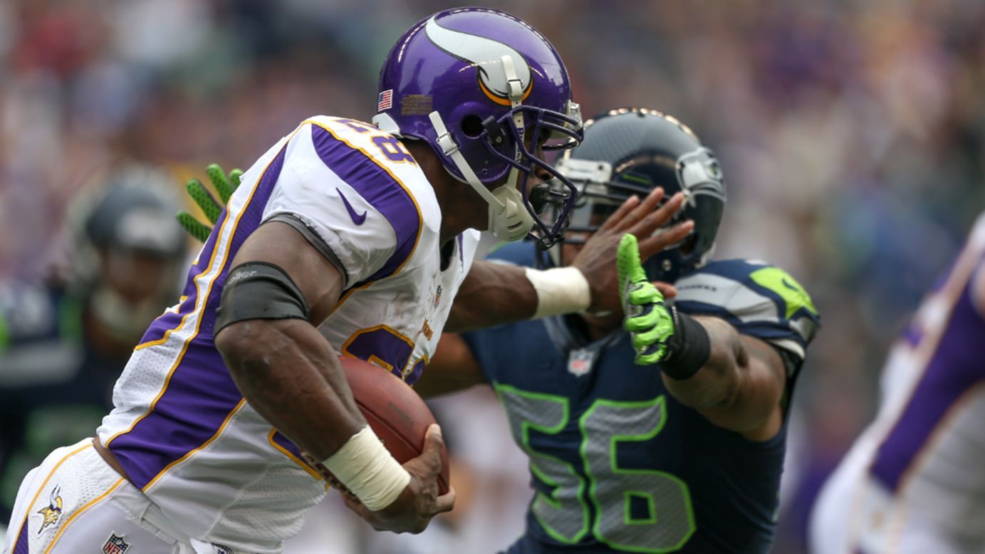 Running back Adrian Peterson of the Minnesota Vikings rushes against Leroy Hill of the Seattle Seahawks at CenturyLink Field on Sunday, November 4, in Seattle.