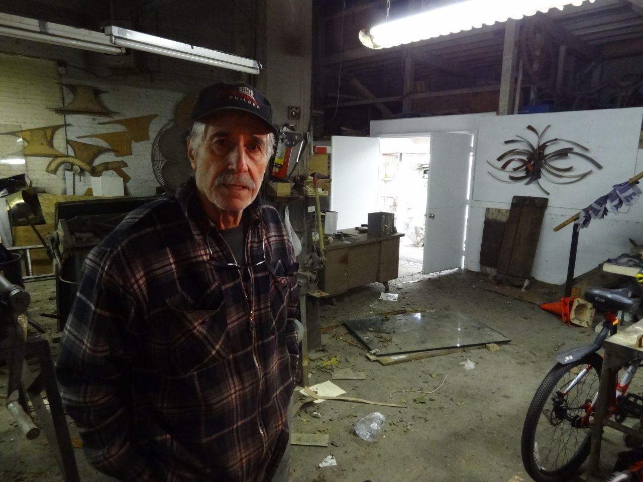 Artist and studio owner Silas Seandel works to restore his facility after floodwaters broke through his doors.