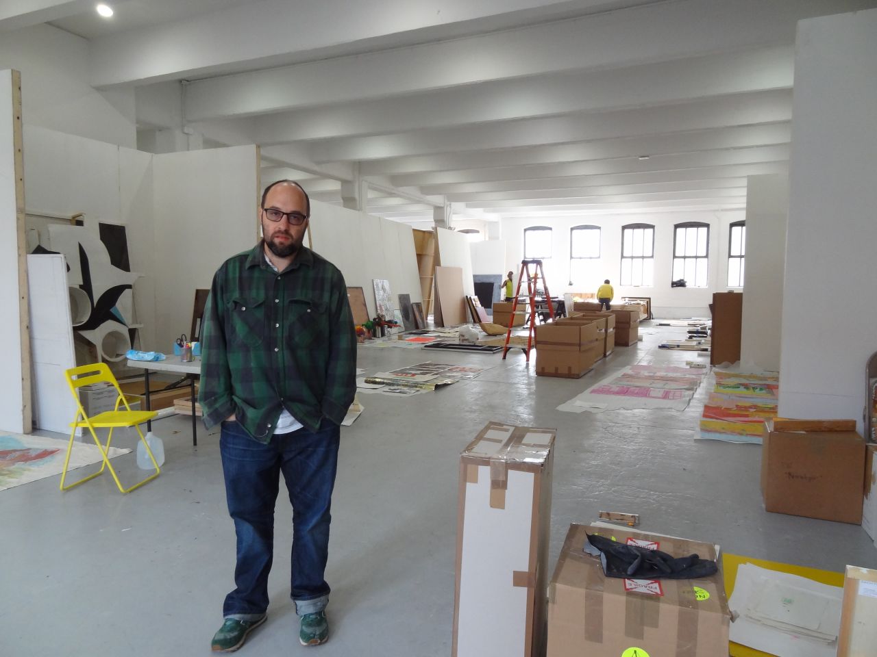Zach Feuer, temporarily using the floor above his gallery, stands in front of art being salvaged from his space.