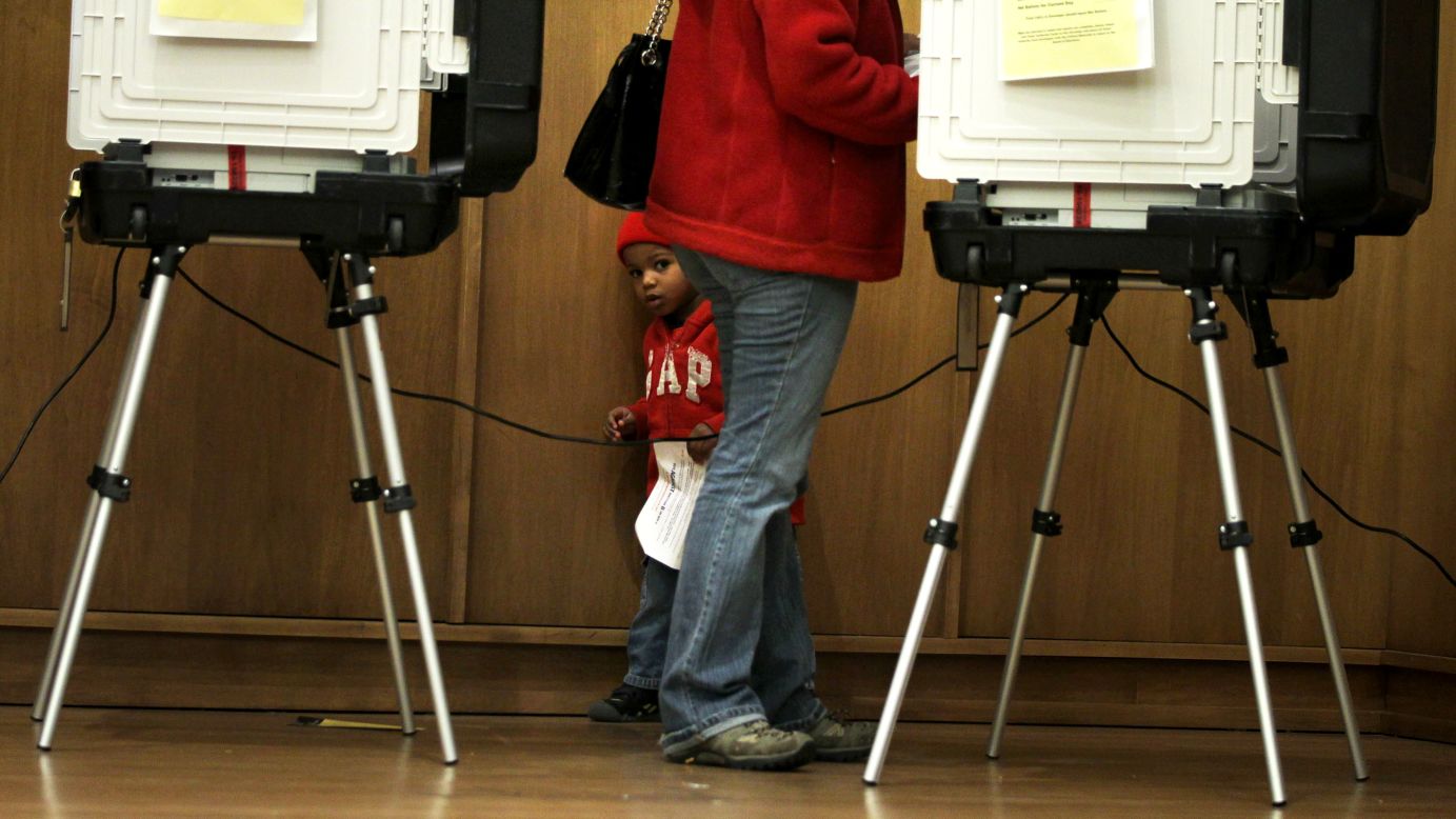 Two-year-old Ariel Ferreras accompanies his mother, Erika, as she votes in Silver Spring, Maryland, on Friday, November 2. Voters 