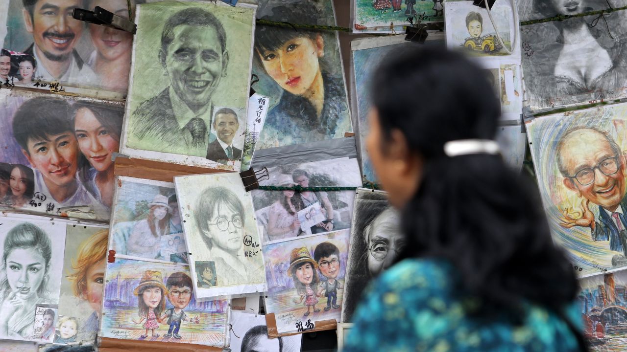 A woman looks at caricatures of US President Barack Obama at a stall in Hong Kong. 