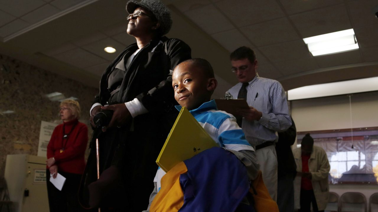 Jalani Hervey, 5, waits with his grandmother, Victoria Gross, while she stands in line to cast a ballot during early voting in Milwaukee on October 22.