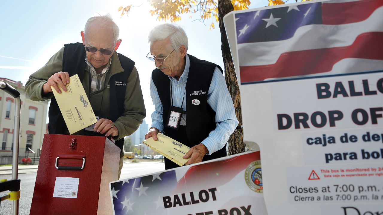 Election judges William Moeller, left, and Harry Sabin transfer ballots from a drop box outside of the library in Denver on October 22.