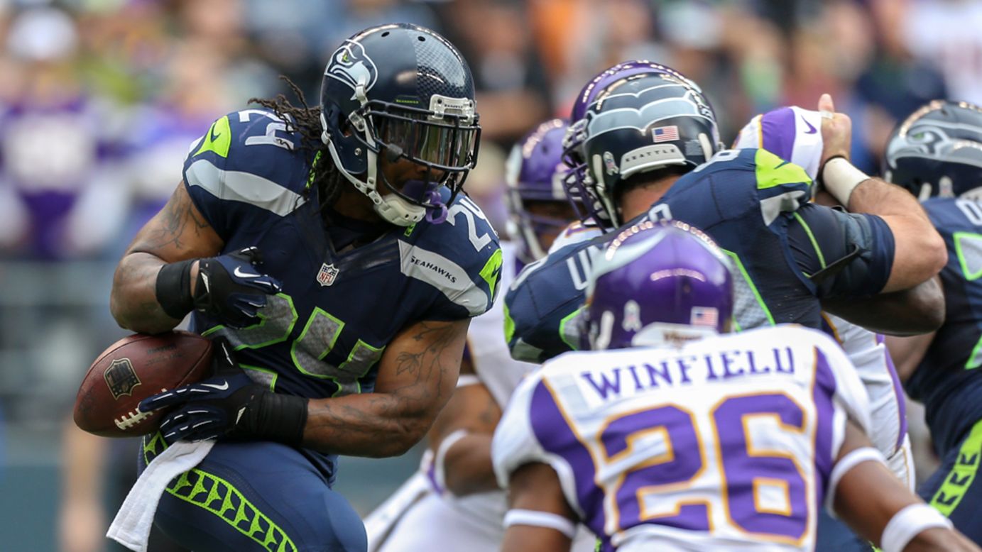 Running back Marshawn Lynch of the Seahawks rushes against cornerback Antoine Winfield of the Vikings on Sunday.