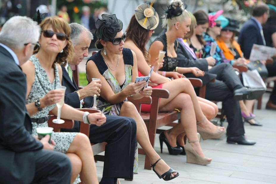 Racegoers in the members area study the form on Melbourne Cup Day.  Twenty-four horses will charge around the 3200 meter track for a total prize pool of $6 million and Australian fame and glory.