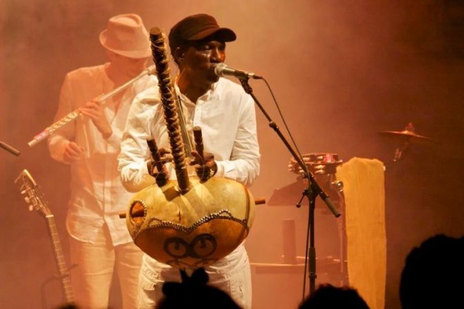 Guinean musician Djeli Moussa Conde, based in Paris for 20 years, plays a kora, an instrument similar to a harp.