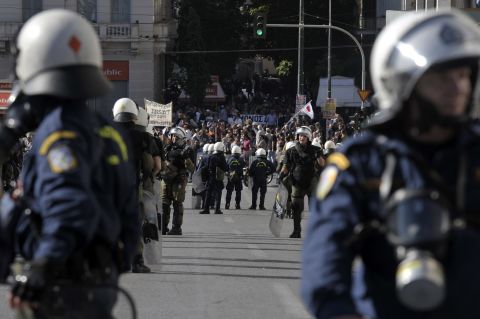 Riot police stand guard as demonstrators march in front of the Greek parliament in central Athens during the protests on November 6, 2012. 