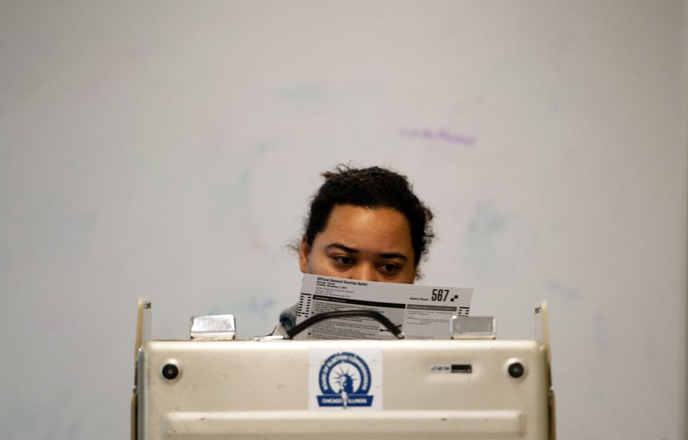 A voter takes a moment to read a paper ballot before casting her vote on Chicago's Northside. 
