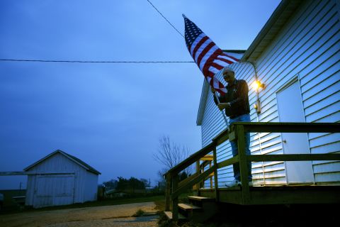 Election inspector Jim Nodorft prepared to hang the U.S. flag outside the Smelser Town Hall as polls opened at 7 a.m. in Georgetown, Wisconsin.