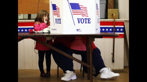 Kaira Ray watches as her grandmother Theresa Bigl votes at the old Town Hall in Bristol, New Hampshire.