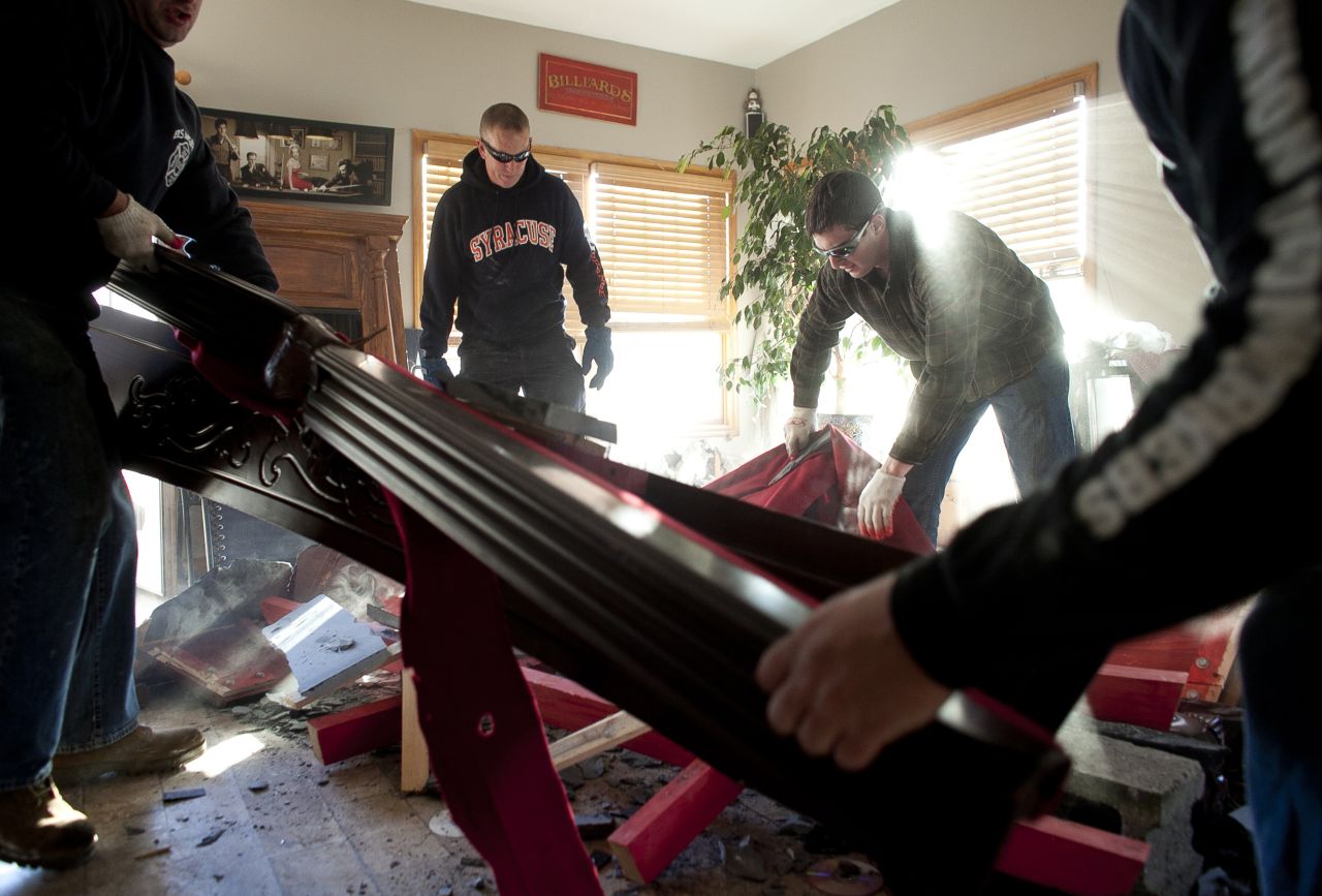 Volunteers who call themselves the Broad Channel Police Department help clean a neighbor's damaged house.