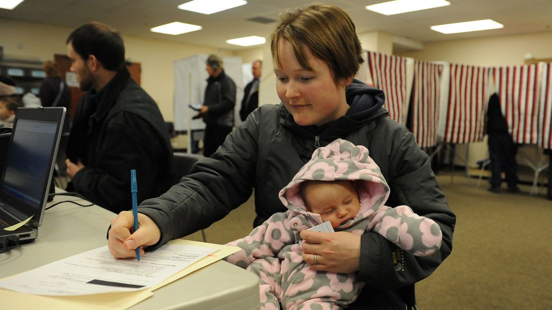 Kalli Hannafious holds her daughter Averie as she signs in for early voting in Anchorage, Alaska on October 2. 
