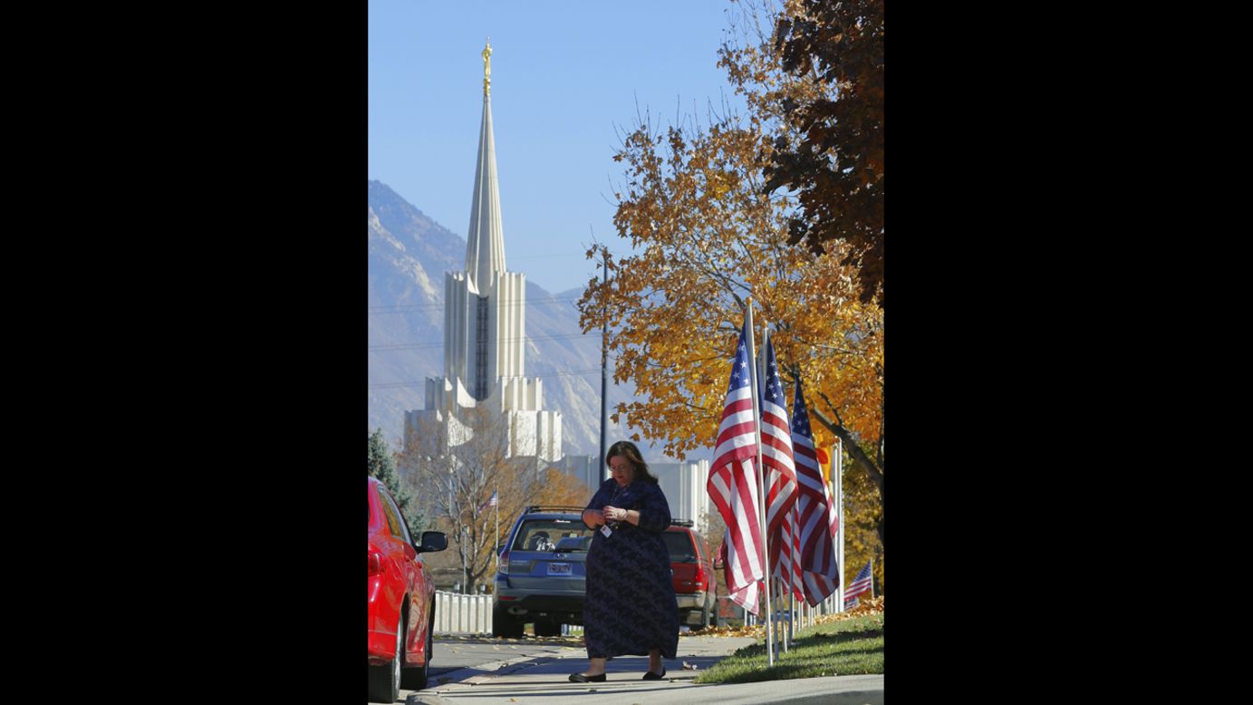 A woman walks out of a polling place after voting in South Jordan, Utah. The Jordan River Utah Temple of the Church of Jesus Christ of Latter-day Saints is visible in the background.