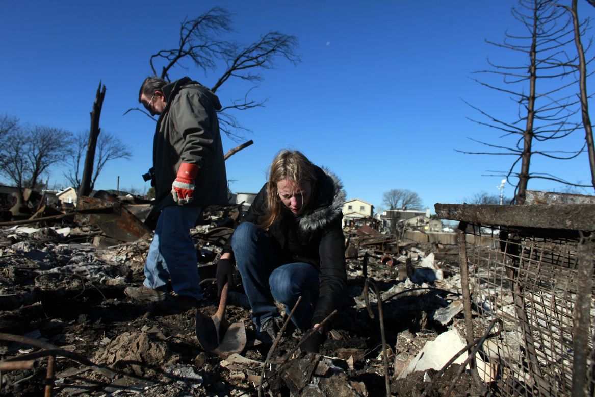 People sift through their damaged home on Sunday in Breezy Point.