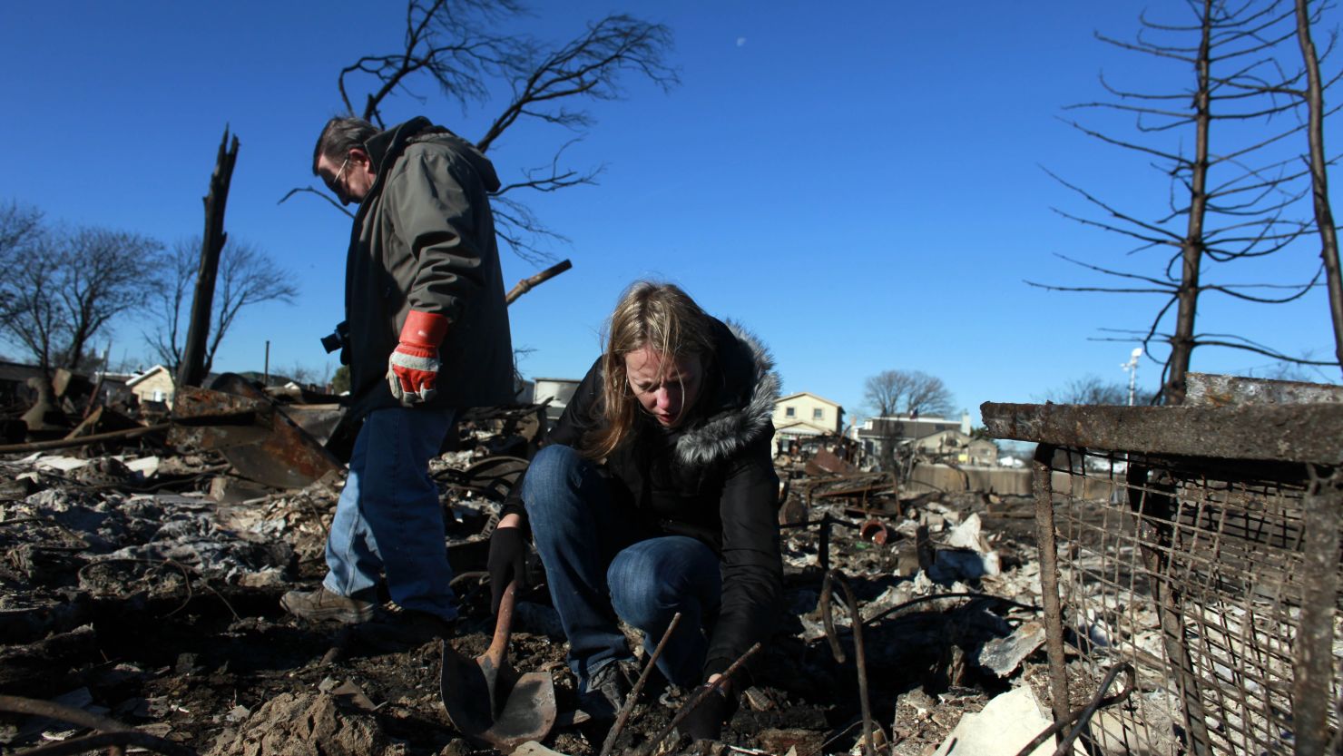 People sift through their damaged home for items to save in the Breezy Point neighborhood of Queens, New York.