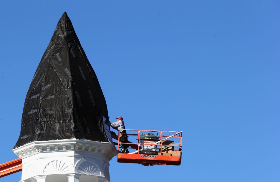 A workman repairs damage to the steeple of the First United Methodist Church on Sunday in Port Jefferson, New York. 