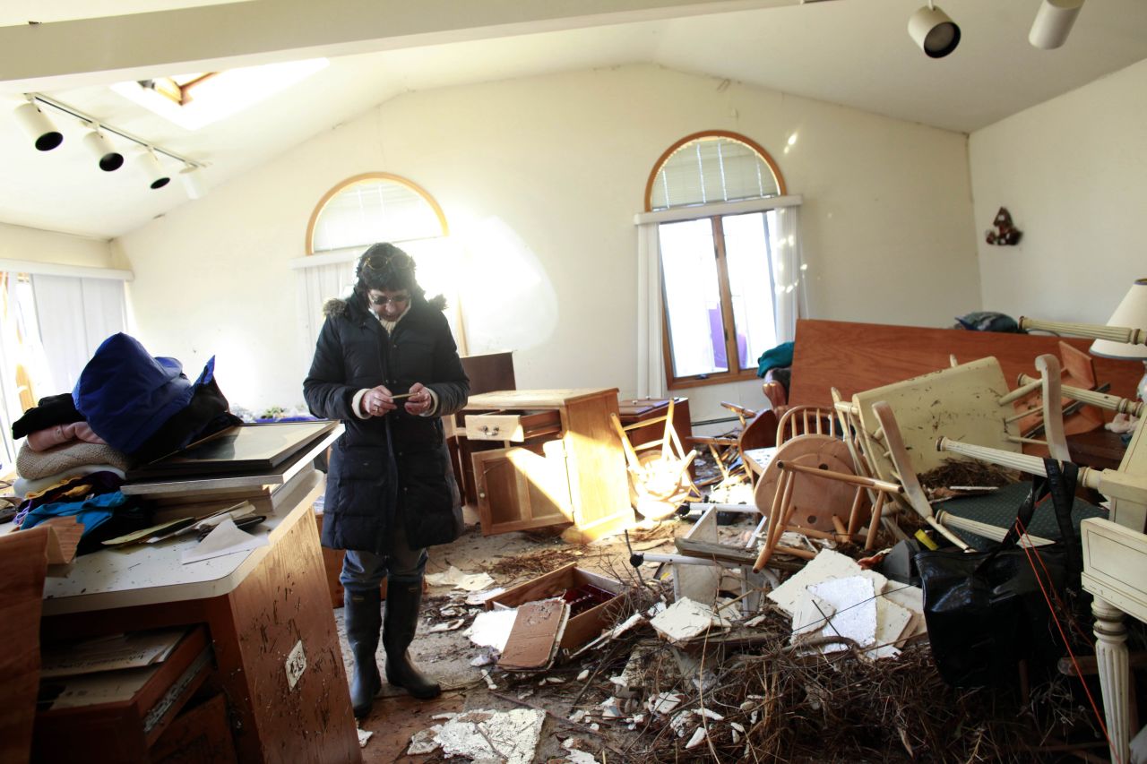 A woman sifts through her mother's damaged home for items to save Sunday in the Breezy Point neighborhood of Queens, New York.