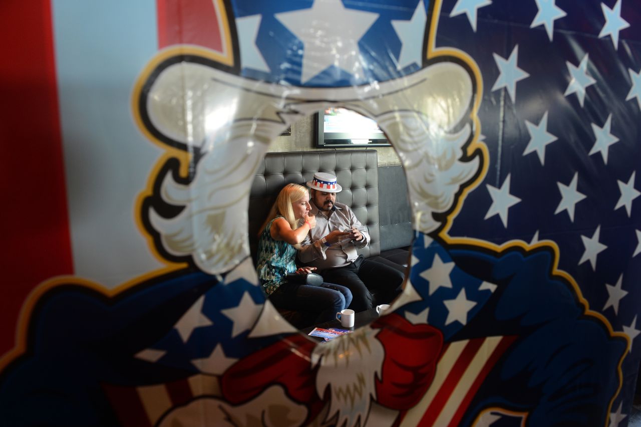 U.S. citizens check their mobile phones during an elections return party Wednesday in Mumbai, India.