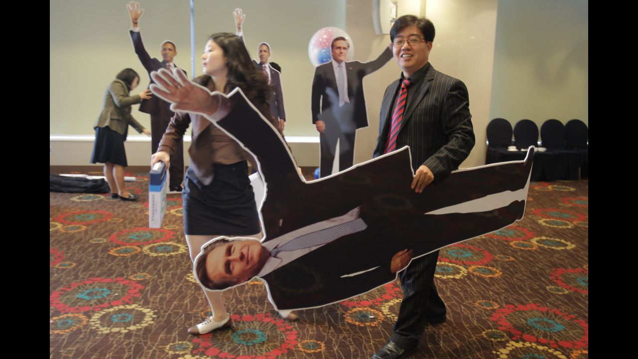 A South Korean man carries a cutout picture of Republican presidential candidate Mitt Romney after an election screening Wednesday in Seoul.