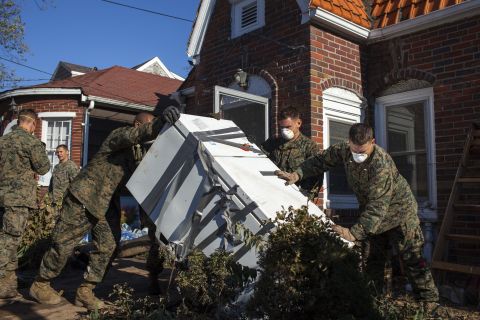 Troops from the 26th Marine Expeditionary Unit and the U.S. Navy help local residents remove household items damaged by Superstorm Sandy on November 6, in the New Dorp Beach neighborhood of Staten Island, New York.
