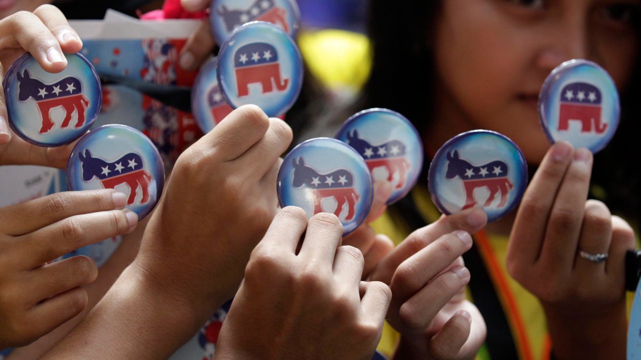 High school students hold up U.S. election pins after casting their votes in a mock election at a U.S.-embassy-sponsored election watch at a shopping mall in Manila, Philippines.