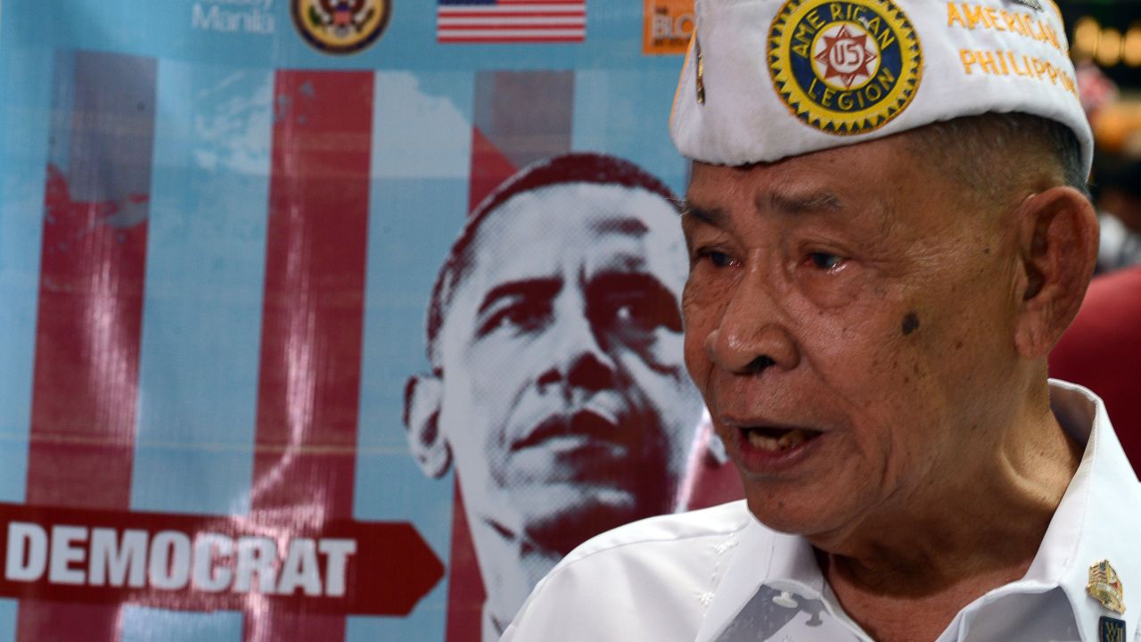A Philippine World War II veteran speaks to reporters next to a portrait of the newly-re elected president, Barack Obama of the Democratic party during a mock US election vote, spearheaded by the US embassy at a shopping mall in Manila on November 7, 2012. US President Barack Obama was re-elected, television networks projected -- only the second time in several decades that a Democrat has won a second term in the White House.    AFP PHOTO/TED ALJIBE        (Photo credit should read TED ALJIBE/AFP/Getty Images)
