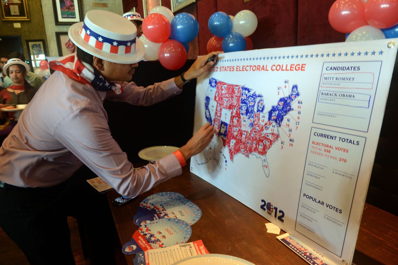 A U.S. consulate staff member marks a U.S. map in Republican and Democrat colors as the results of the U.S. presidential election are announced during a election returns party in Mumbai on Wednesday. 