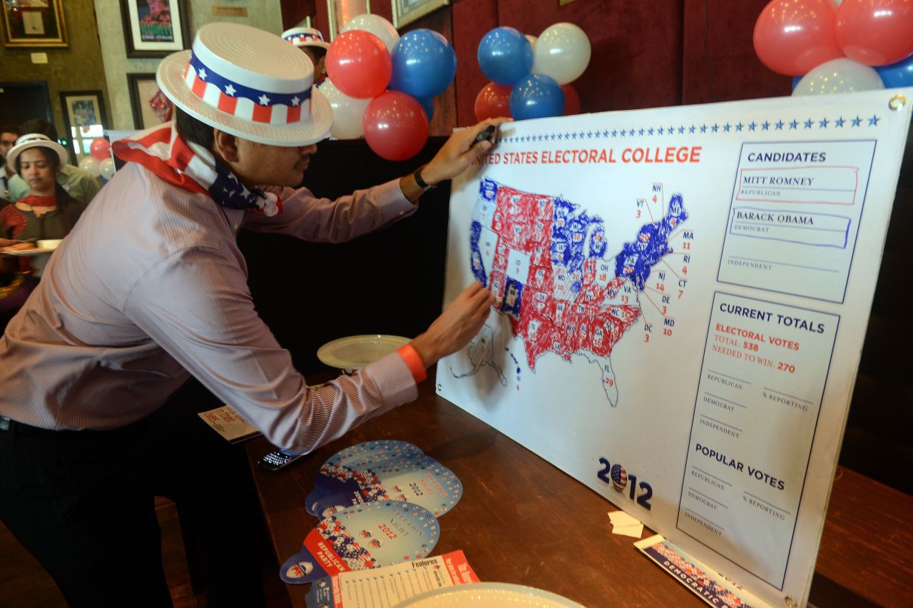 A U.S. consulate staff member marks a U.S. map in Republican and Democrat colors as the results of the U.S. presidential election are announced during a election returns party in Mumbai on Wednesday.