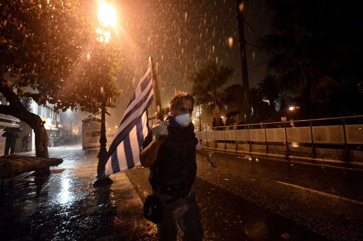 A man runs away from clashes between protesters and riot police outside the parliament in Athens on November 7, 2012.