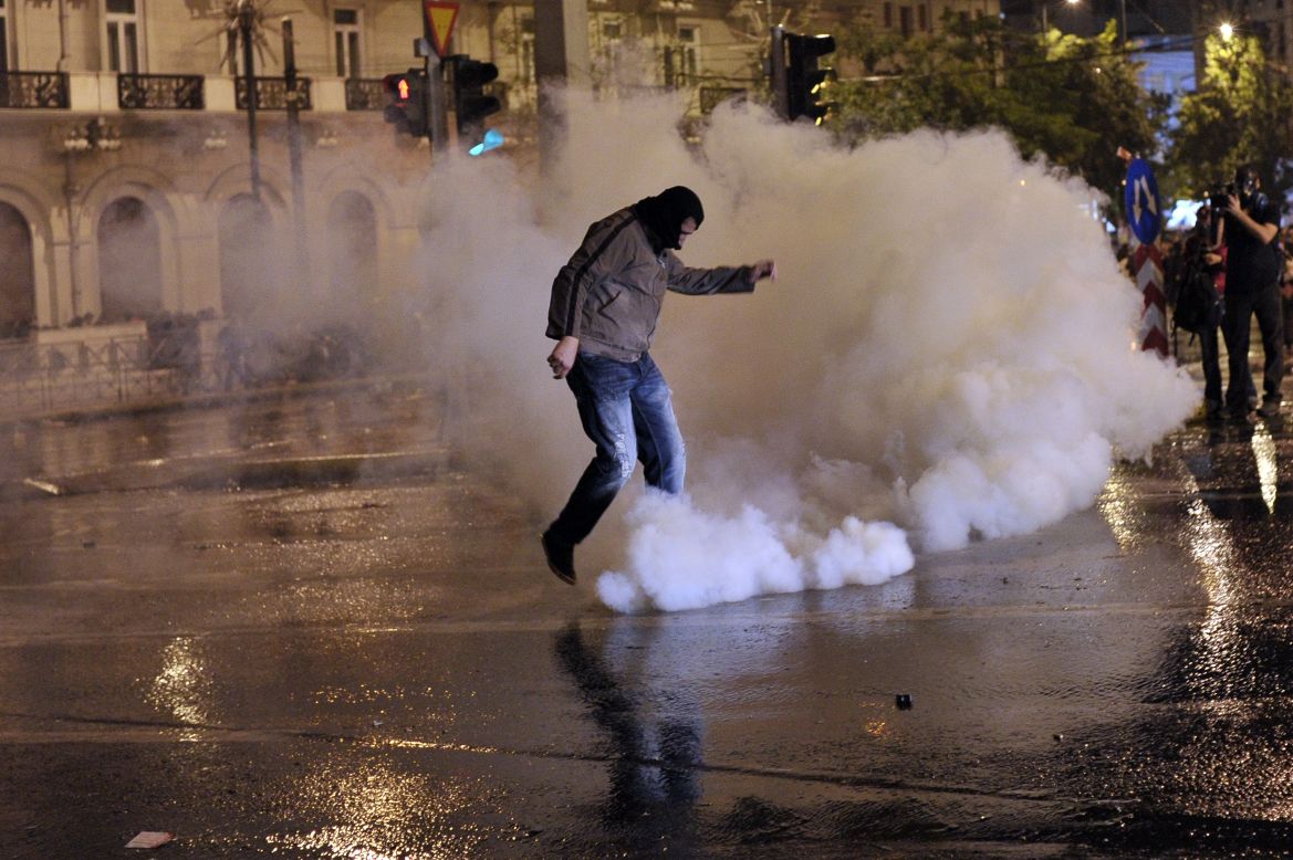A protester kicks away a tear gas canister during a demonstration in Athens on November 7, 2012.
