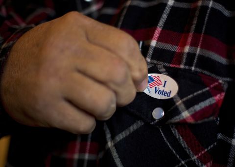  A man puts on an "I Voted" sticker after casting his ballot in Otter Creek, Iowa, on Tuesday. 
