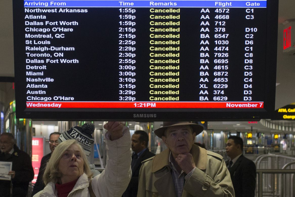 Travelers check a list of canceled flights in New York's LaGuardia Airport on Wednesday.