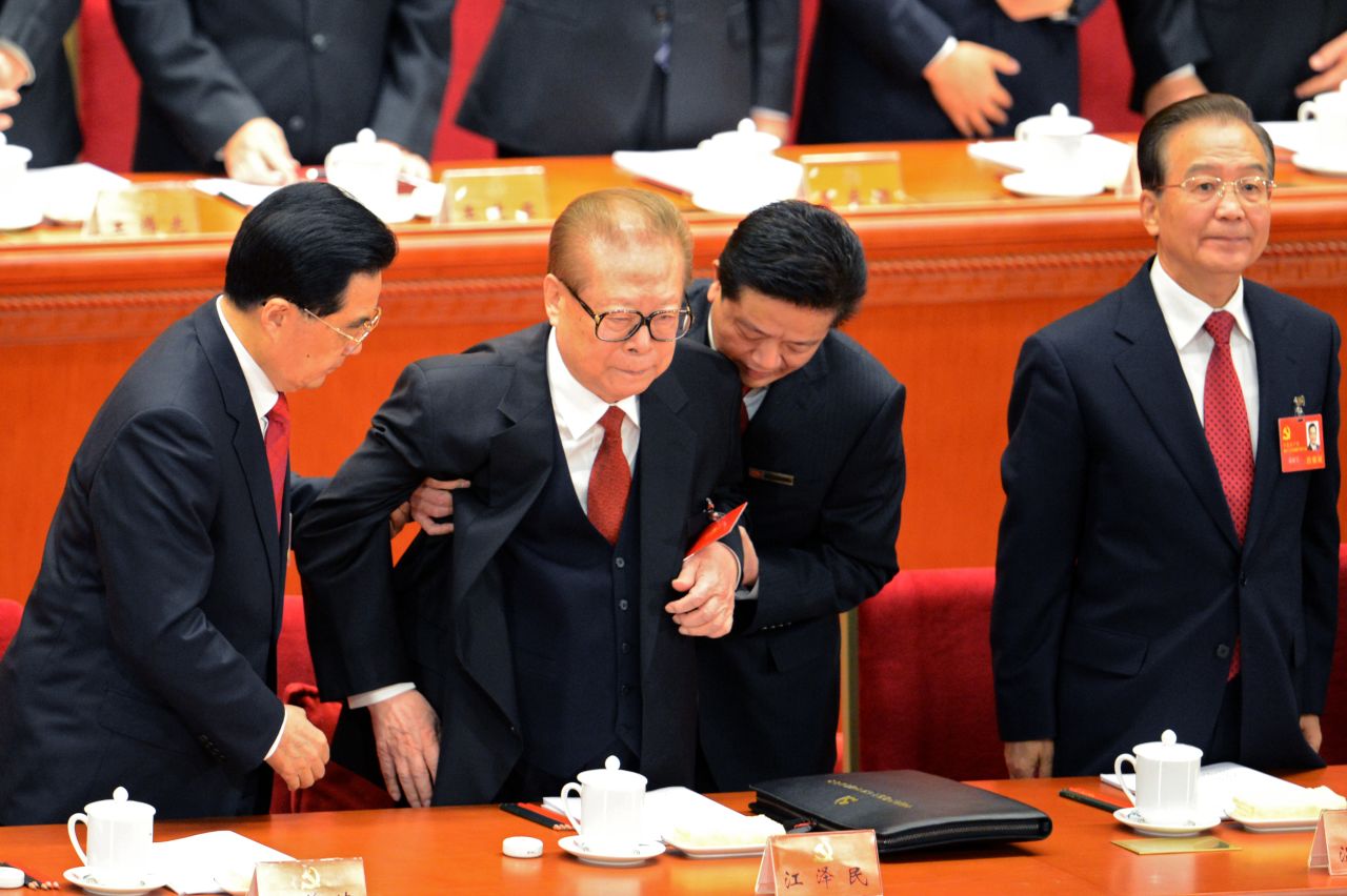 Hu helps former Chinese president Jiang Zemin to stand up as Prime Minister Wen Jiabao looks on at the opening of the 18th Communist Party Congress.
