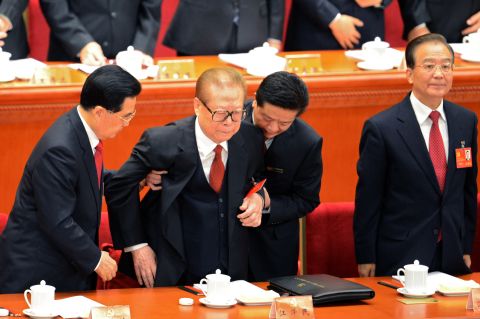 Hu helps former Chinese president Jiang Zemin to stand up as Prime Minister Wen Jiabao looks on at the opening of the 18th Communist Party Congress. 