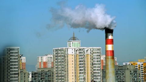 Pollutants billow out of a chimney near residential apartment blocks in Beijing, March 2, 2011.