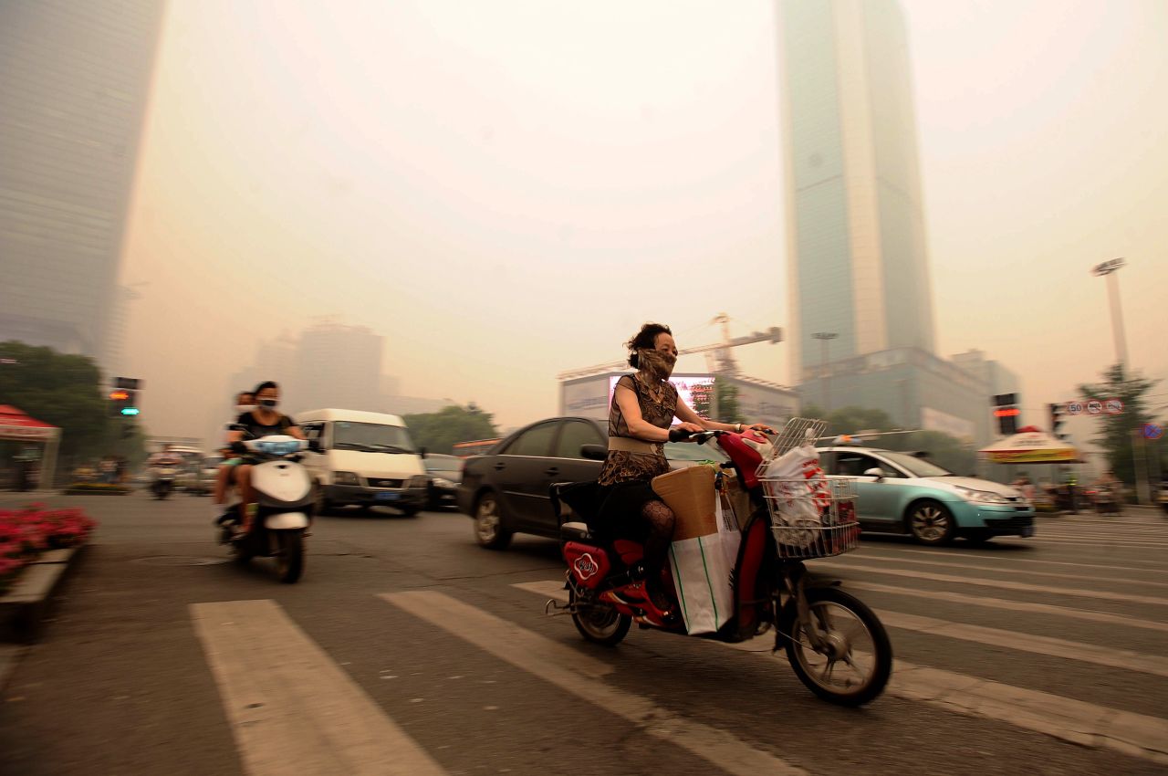 Chinese motorists wear masks as they make their way along a busy intersection in central China's Hubei province in June 2012. A landmark study in 2013 by Chinese and international academics found toxic air slashed an average of five and a half years off life expectancy in northern China. 