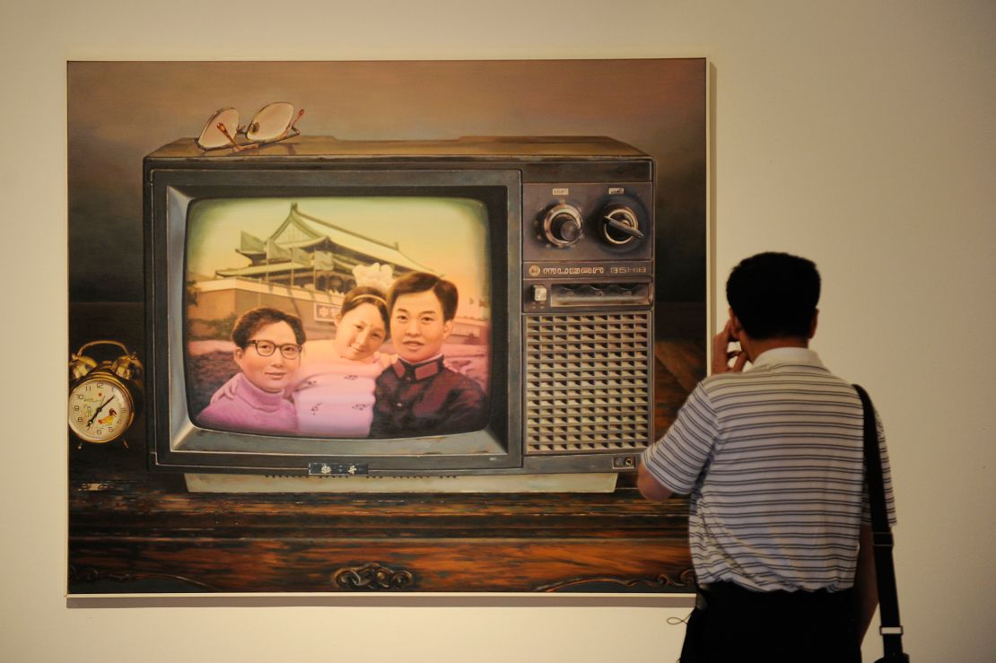 A man looks at a painting named 'Better To Have Only One Child' at the China National Art Museum in Beijing in 2012. 