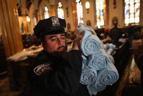 A police officer carries blankets donated by Ikea for people affected by Superstorm Sandy in Brooklyn.