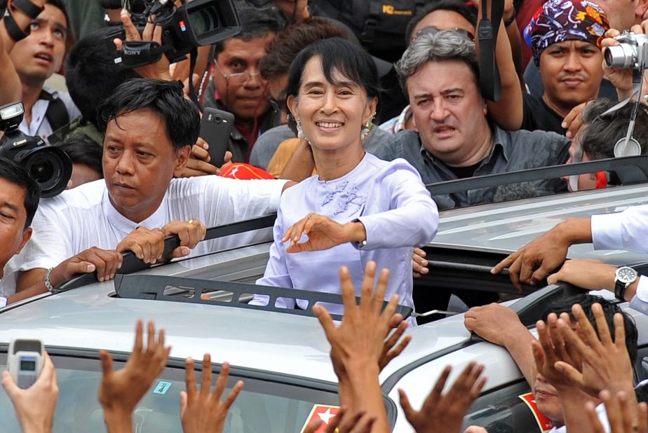 Myanmar opposition leader Aung San Suu Kyi waves to the crowd as she leaves National League for Democracy  headquarters in Yangon on April 2. She hailed a 'new era' for Myanmar and called for a show of political unity after her party claimed a major victory in landmark by-elections. 