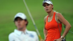 Caroline Wozniacki watches boyfriend Rory McIlroy during the continuation of the weather-delayed first round of the Singapore Open.