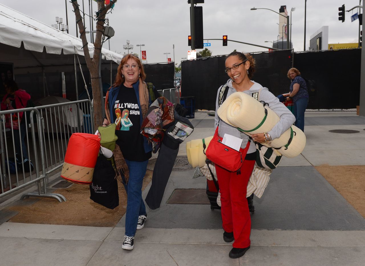 Two people arrive at tent city ready to set up camp.