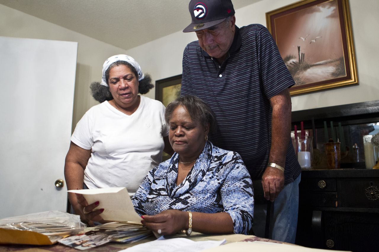Sgt. Rodney Davis' sister, Debra Ray, standing, and brother Gordon Davis Jr. look at a letter with Gordon's wife, Josephine. The family has a collection of letters written by the Marine after he enlisted in 1961.