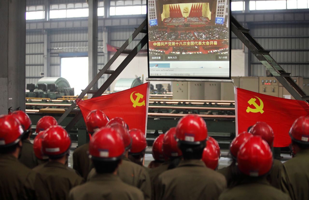 Workers gather to watch Hu's address to the Communist Party Congress. Hu called for stepped-up political reform and a revamped economic model on the first day of the congress.