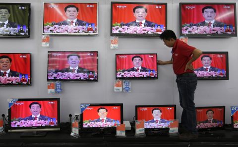 A man adjusts a television screen showing a live broadcast of Hu speaking at the Party Congress at a supermarket in Wuhan, Hubei province on November 8.