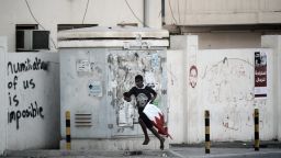 A Bahraini Shiite protester runs for cover from riot police after a crackdown on an anti-government demonstrator. They were protestsing against the killing of 16-year old Ali Abbas Radhi in the village of Diraz, west Manama on  November 9, 2012. 