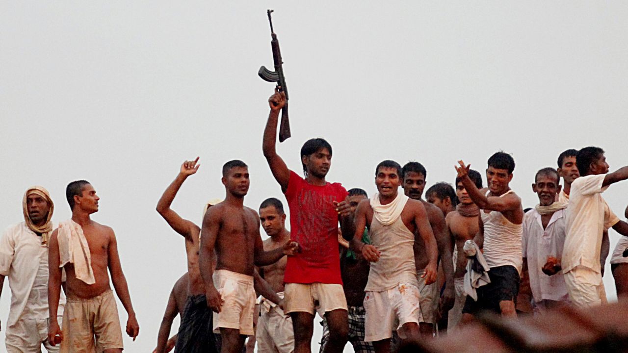 Sri Lankan prisoners try to get a view of rioting inmates at Welikada prison in Colombo on November 9, 2012. 
