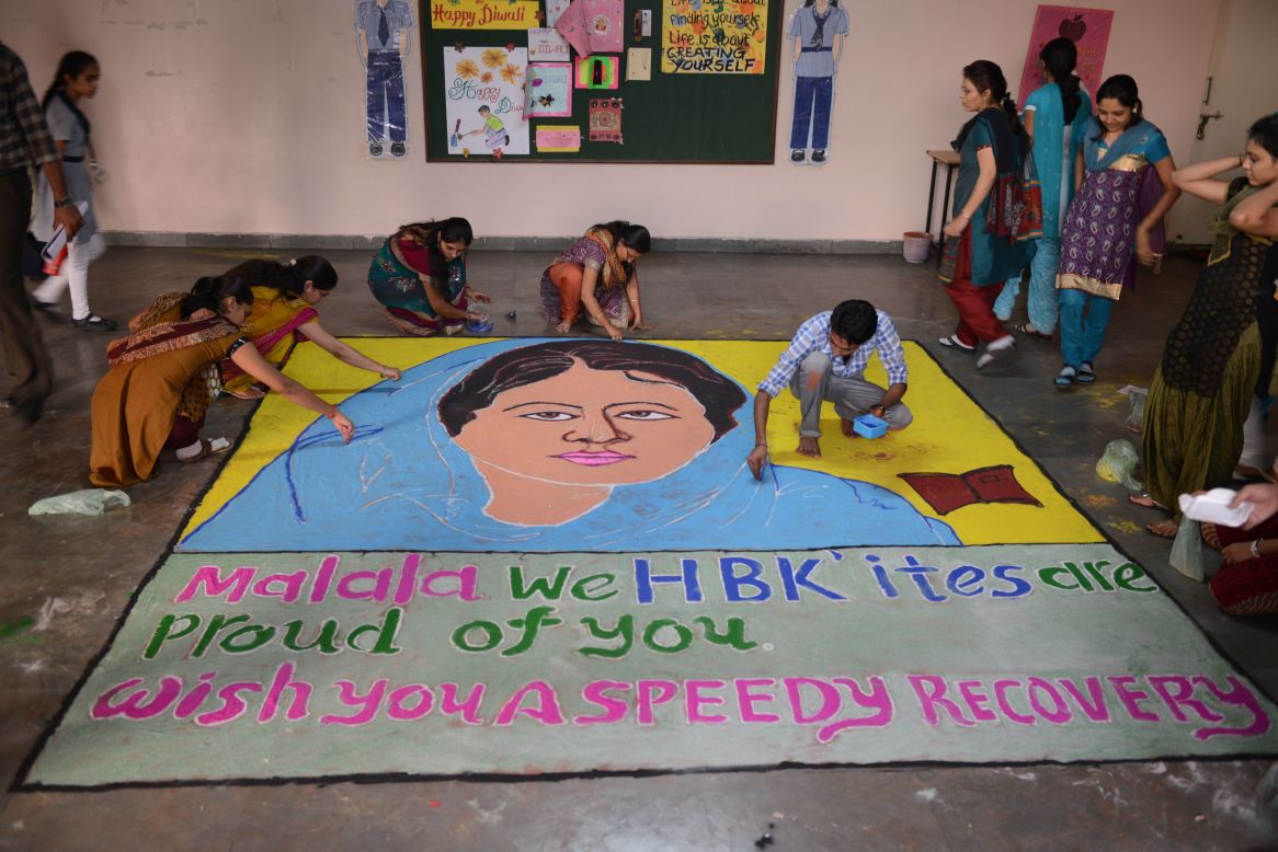 Indian teachers add finishing touches to a "Malala Rangoli" at a high school in Ahmedabad on Saturday.